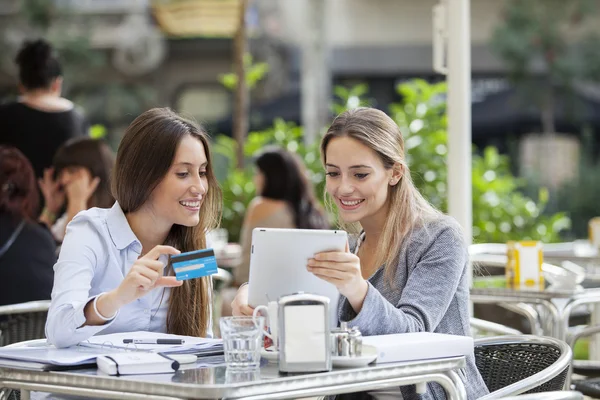 Vänner köper online med en digital tablet och kreditkort på terrassbaren — Stockfoto