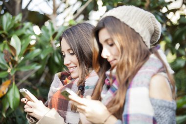 Cep telefonunu kullanarak iki genç kadın