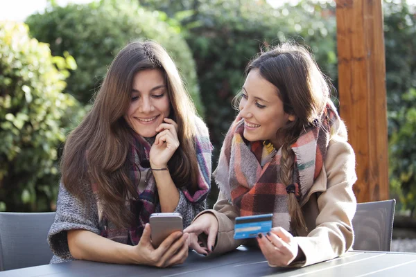 Dos jóvenes amigos de compras en línea con una tarjeta de crédito y un teléfono — Foto de Stock