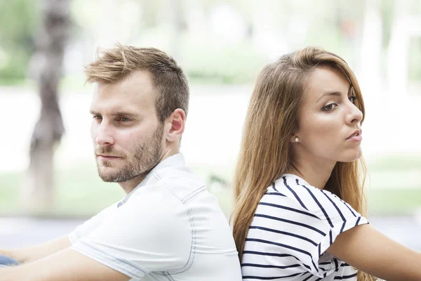 Side view of annoyed couple standing back to back — Stock Photo, Image