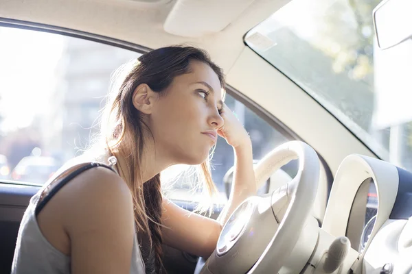 Retrato de mujer cansada conduciendo coche y mirando a través de la ventana — Foto de Stock