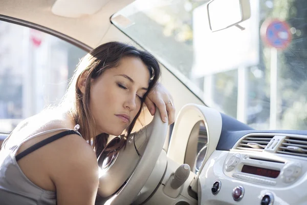 Mujer cansada dormida en el volante en su coche — Foto de Stock