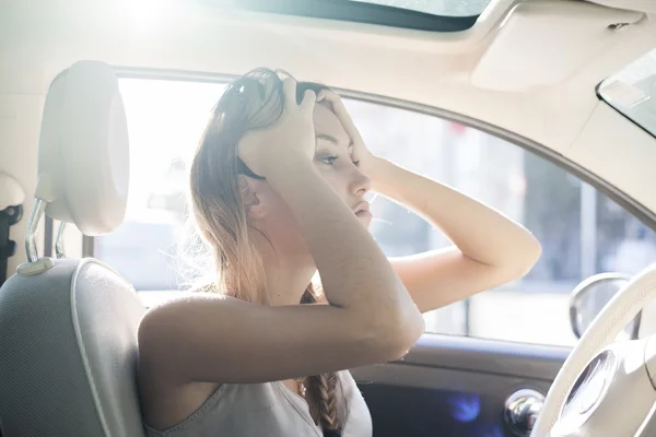 Problemas en la carretera, mujer cansada toca su frente con las manos mientras está en un coche — Foto de Stock