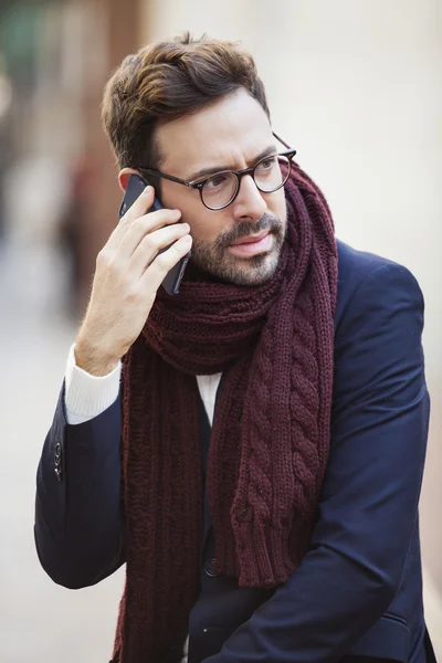 Porträt eines gutaussehenden Mannes im urbanen Hintergrund, der am Telefon spricht — Stockfoto