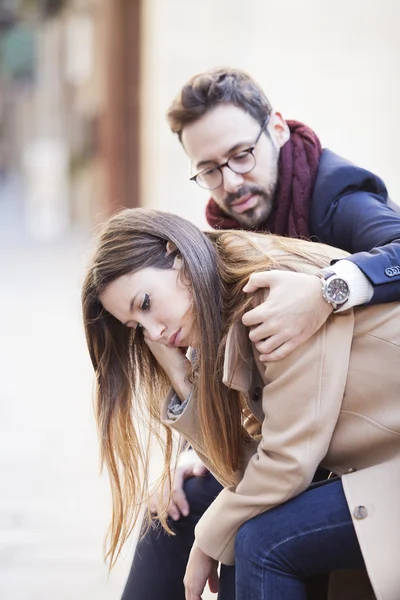 Man consoles his sad girlfriend in the street — Stock Photo, Image