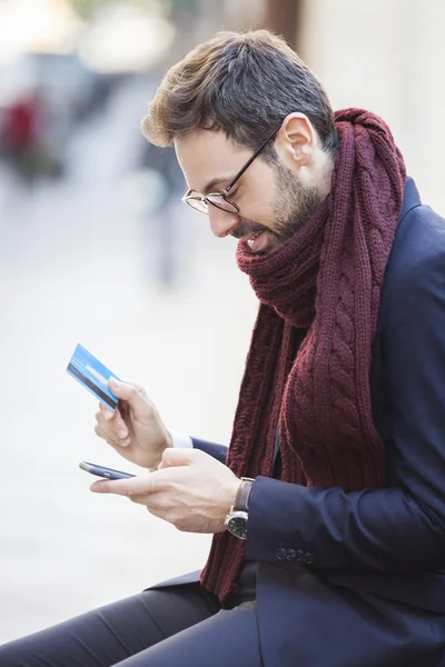 Mann bezahlt mit Kreditkarte am Telefon — Stockfoto