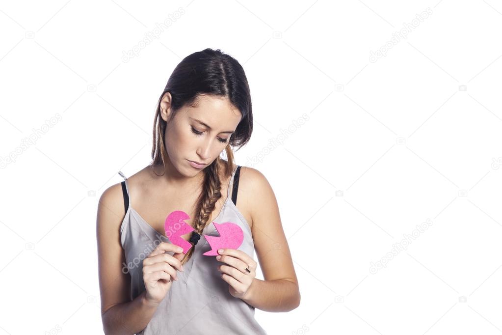 Portrait of sad young woman holding broken heart in hands, about to cry, isolated white background