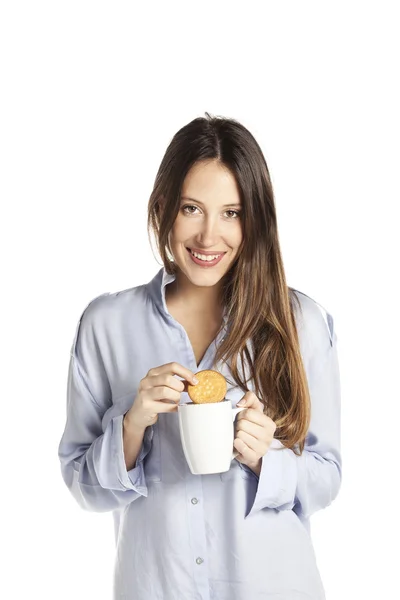 Krásná mladá žena pití kávy se souborem cookie v pyžámku. Snídaně koncept — Stock fotografie