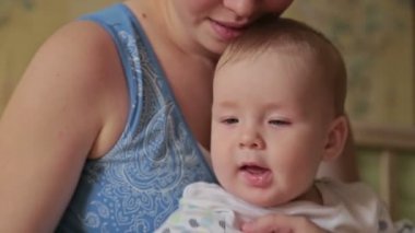 Bebek anne kucağında oturan.
