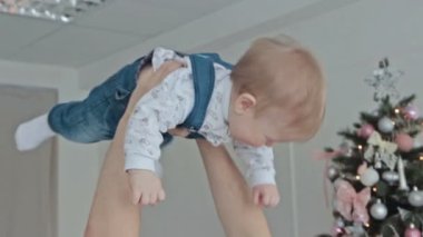 Genç baba bebek havaya atar.