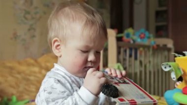 Erkek bebek onu ağız oyuncak kitap alır