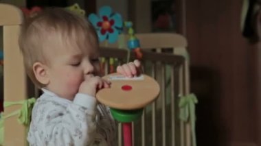 Erkek yatakta oturmuş oyuncakla oynarken mutlu bebek