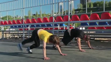 Burpee egzersiz ve başka bir egzersiz yapıyor kızlar