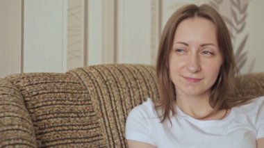 Çekici genç kadın kanepe oturma ve gülümseyen