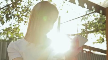 Gün batımında Tablet Pc kullanan kadın