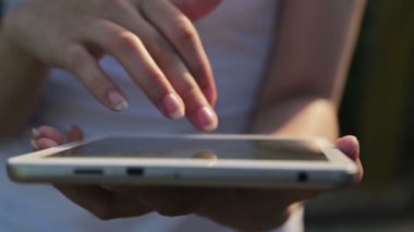 Gün batımında Tablet Pc kullanan kadın