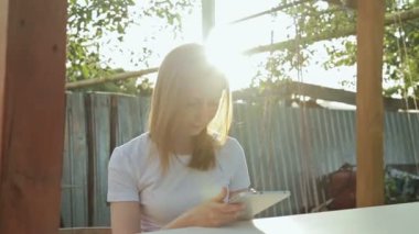 Gün batımında Tablet Pc kullanan kadın