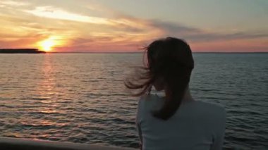 Gün batımında gezinti gemisinde genç kadın silüeti