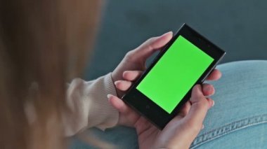 Akıllı telefon telefon ile yeşil perde tutan kadın
