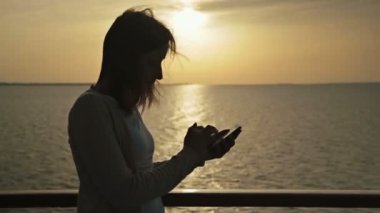 Akıllı telefon deste kadınla silüeti cruise gemi güneş doğarken