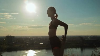 Gün batımında - dans poz efendisi pratik Yoga parkta kadın