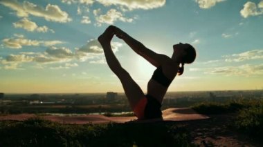 Gün batımında tekne poz parkta yüzen içinde yoga yaparken kadın