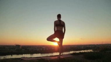 Gün batımında pratik Yoga parkta kadın