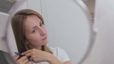 Genç güzel kadın aynanın önünde onun saç tarama