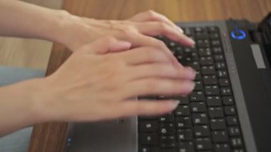 Eller dizüstü bilgisayarda klavyede yazıyor.