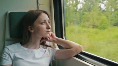 genç kadın bir tren pencereden dışarı bakarak
