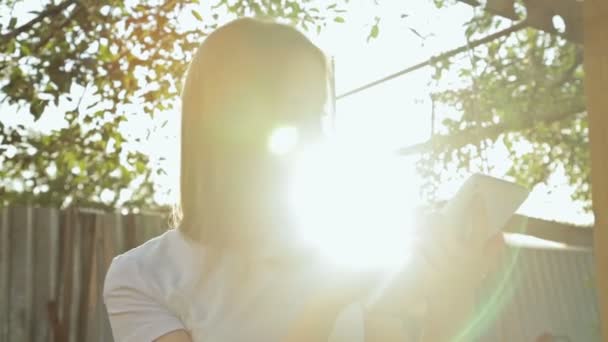 Femme utilisant la tablette PC au coucher du soleil 