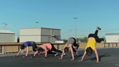 Burpee egzersiz ve başka bir egzersiz yapıyor kızlar