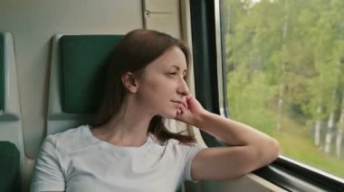 genç kadın bir tren pencereden dışarı bakarak