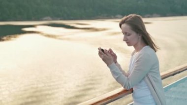 Cruise gemi güvertesinde cep telefonu kullanan kadın