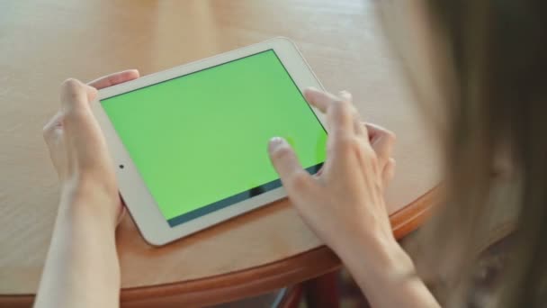 Femme regardant ordinateur tablette avec écran vert dans le café 
