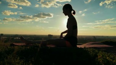 Gün batımında ormandaki Ashtanga yoga yaparken kadın