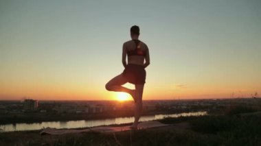 Gün batımında pratik Yoga parkta kadın