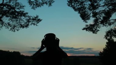 Genç kadın ormanda güneş battıktan sonra dans