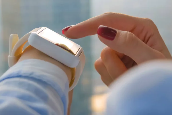 Mujer mano usando reloj elegante blanco usable en la oficina - vista lateral de cerca — Foto de Stock