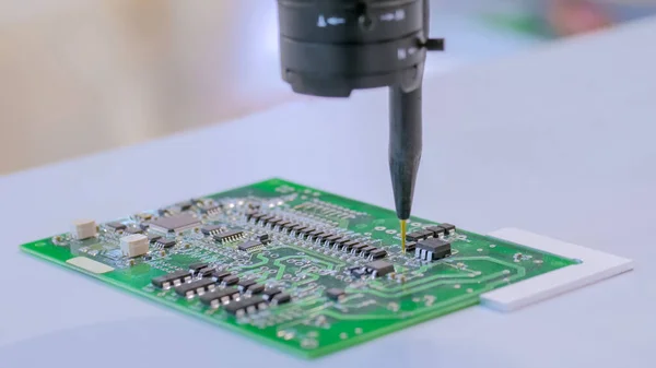 Manipulador automático con aguja dispensadora durante el trabajo con SMT pcb - de cerca — Foto de Stock