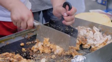 Yavaş çekim: şef sokak yemekleri festivalinde ızgara tavuk eti kesiyor