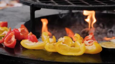 Sokak gıda pazarında ızgarada çan biberi pişirme işlemi. Kapatın.