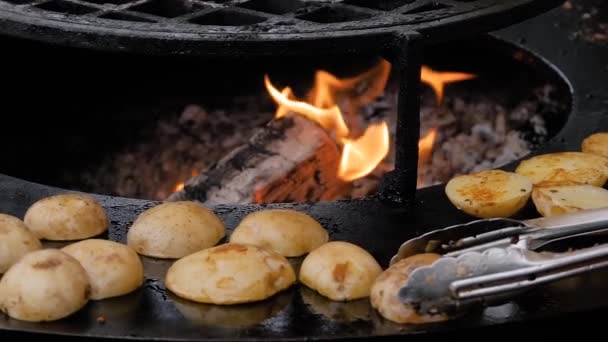 Processus de cuisson des pommes de terre jaunes sur le gril au marché alimentaire de rue - fermer — Video