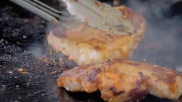Slow motion: chef with tongs grilling meat steaks on brazier with hot flame — Stock Video