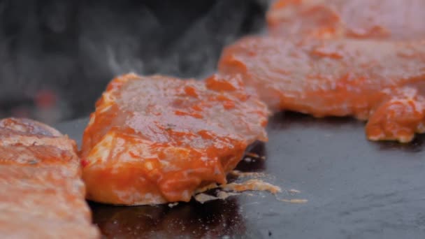 Slow motion: kock med tång grillning kött biffar på fräs med varm låga — Stockvideo