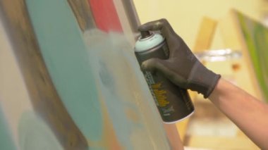 Adam graffiti festivalinde konserve kutusundan boya püskürtüyor. Yavaş çekim.