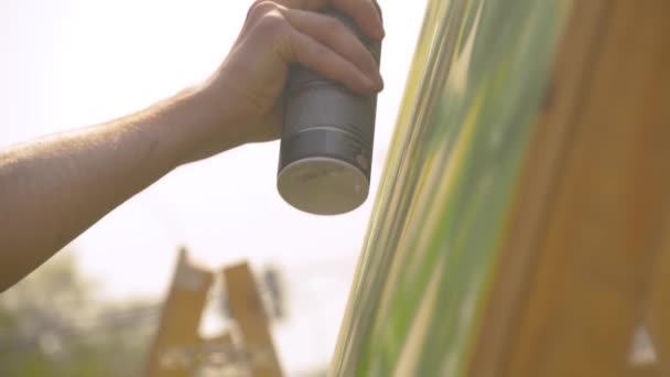 Lento movimiento: hombre pintando a mano colorido graffiti en la superficie de madera - de cerca — Vídeo de stock