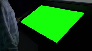 Yeşil ekran konsepti - Sergide boş yeşil ekran kioskuna bakan kadın