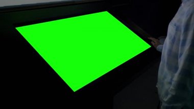 Yeşil ekran konsepti - Sergide boş yeşil ekran kioskuna bakan kadın