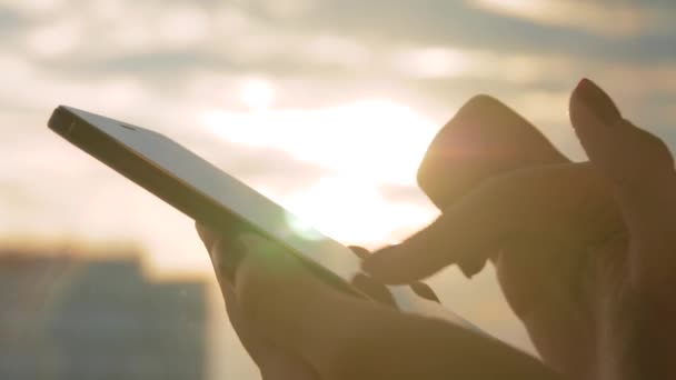 Kobieta korzystająca ze smartfona przed ciepłym zachodem słońca niebo: z bliska widok z boku — Wideo stockowe